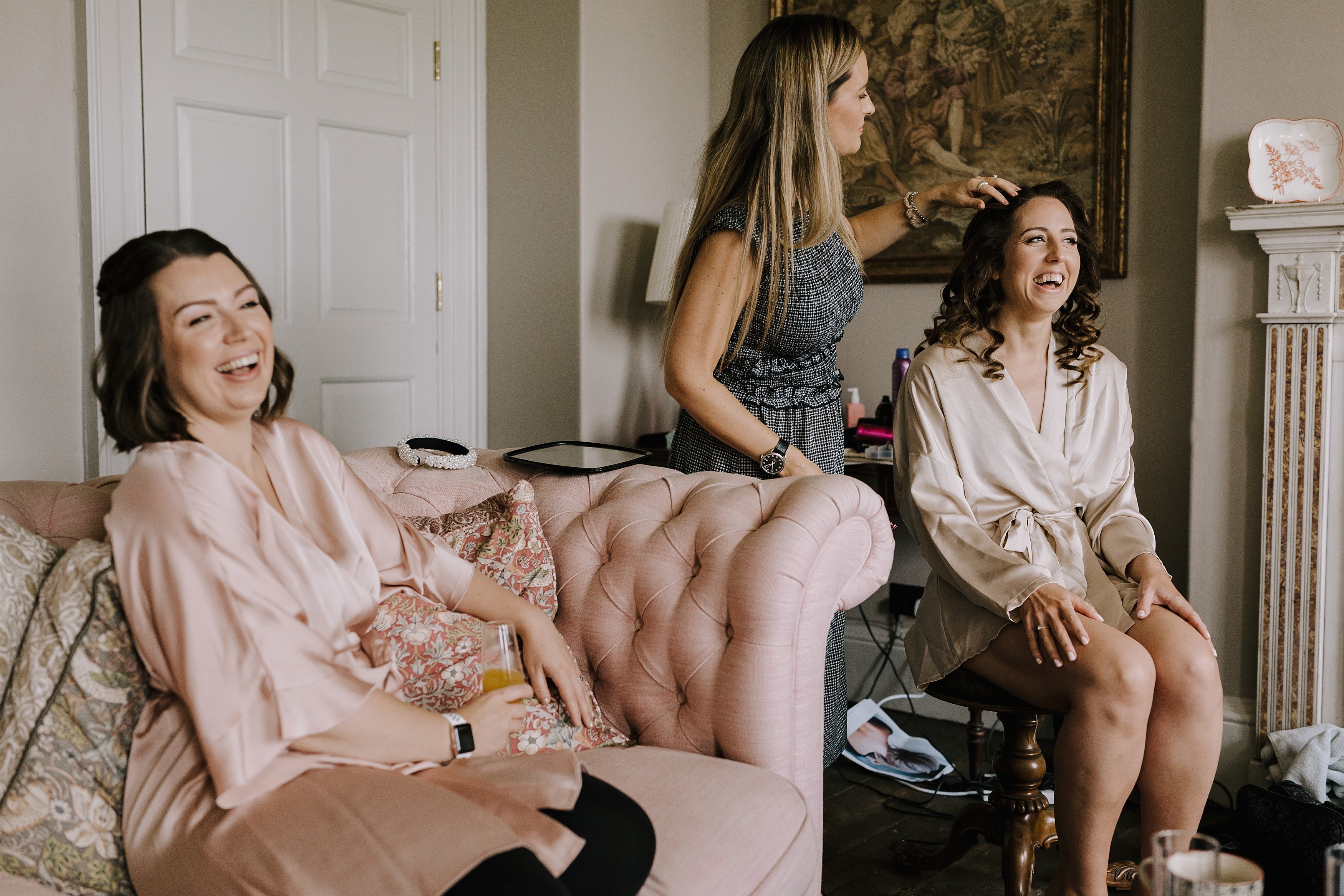 Bridesmaids laughing together with Goodnestone historic artefacts in the background