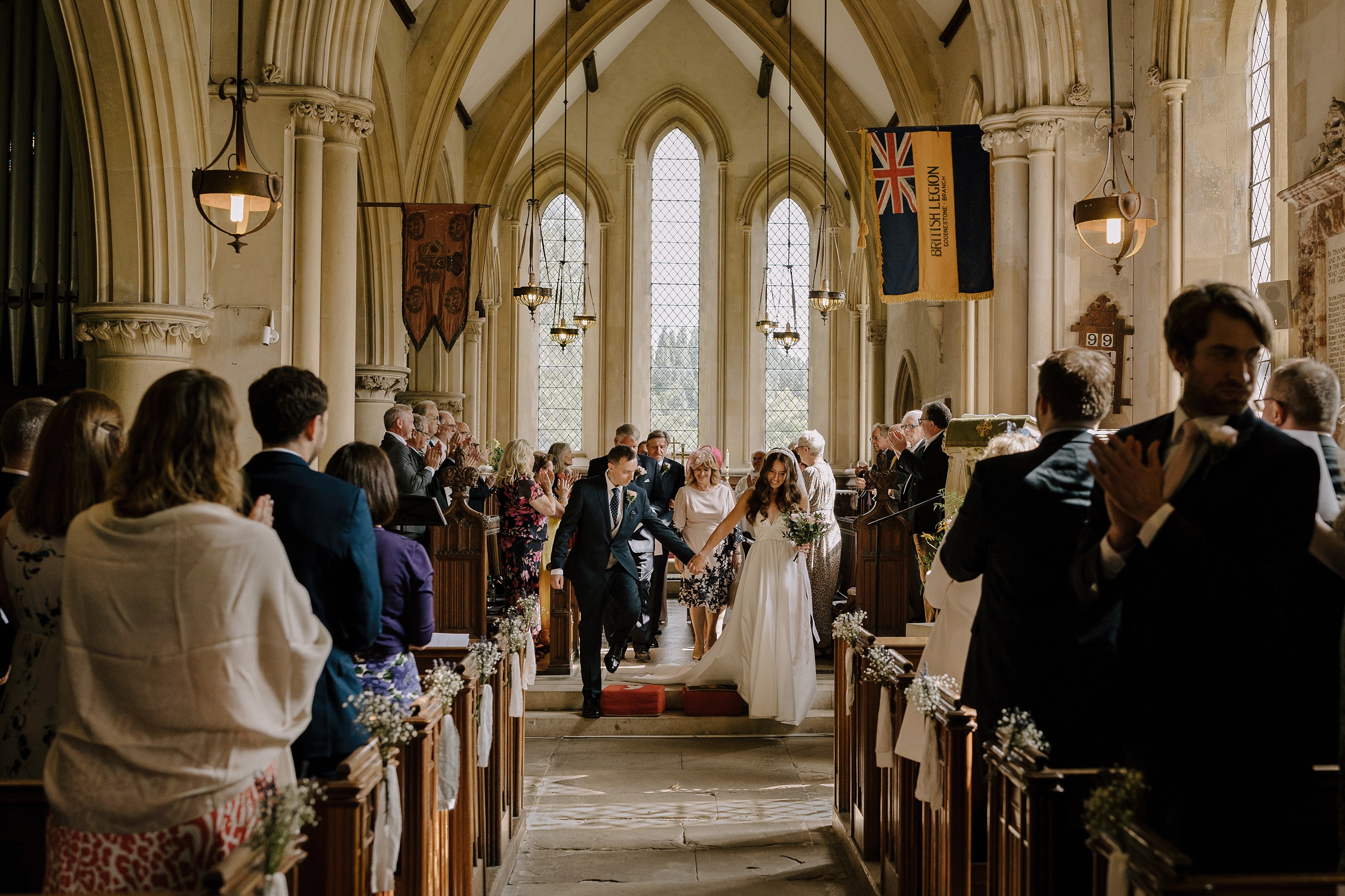 Bride and groom walk back up the aisle hand in hand