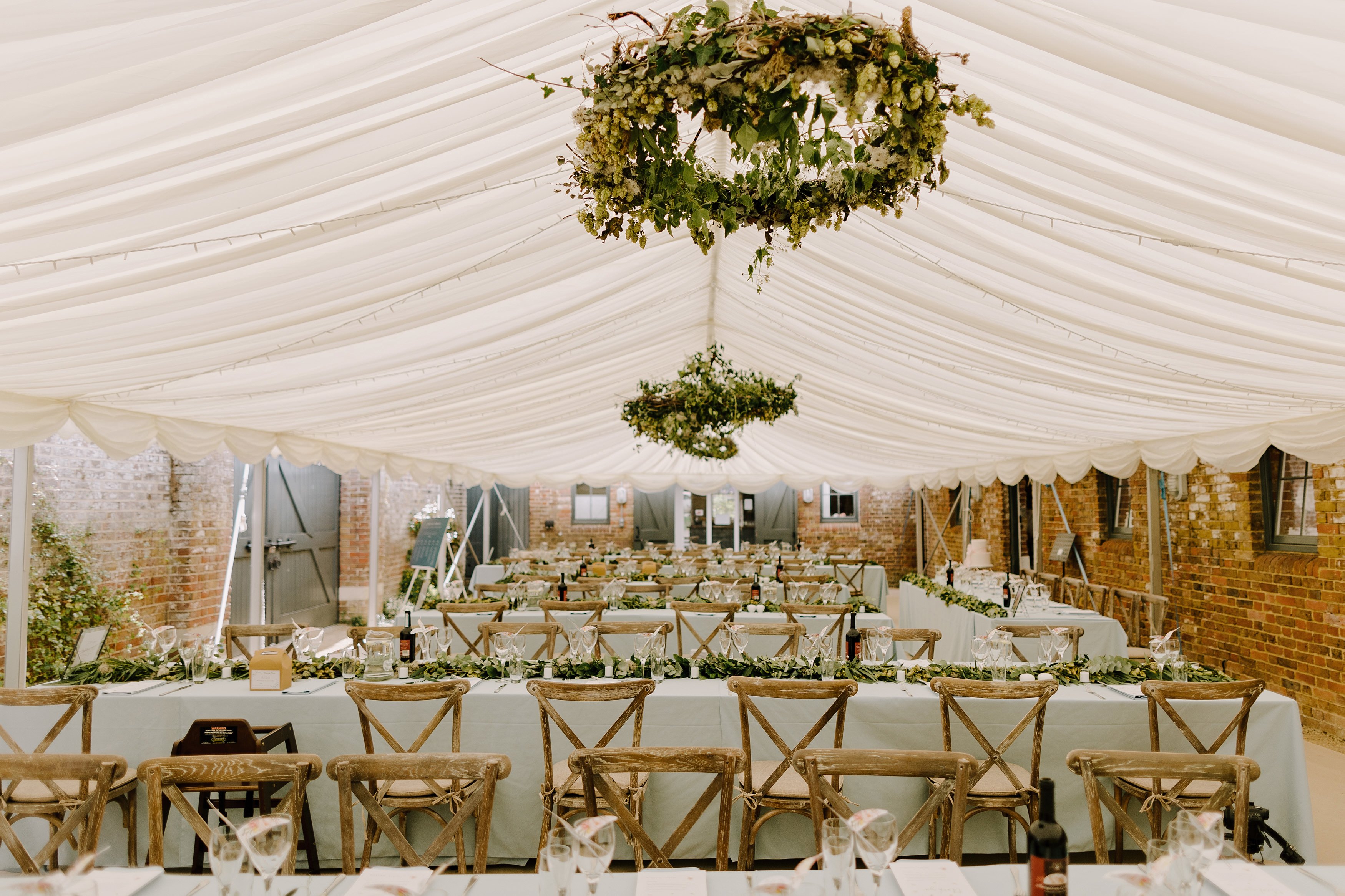 Empty wedding marque all set up for a wedding reception with flowers and place settings