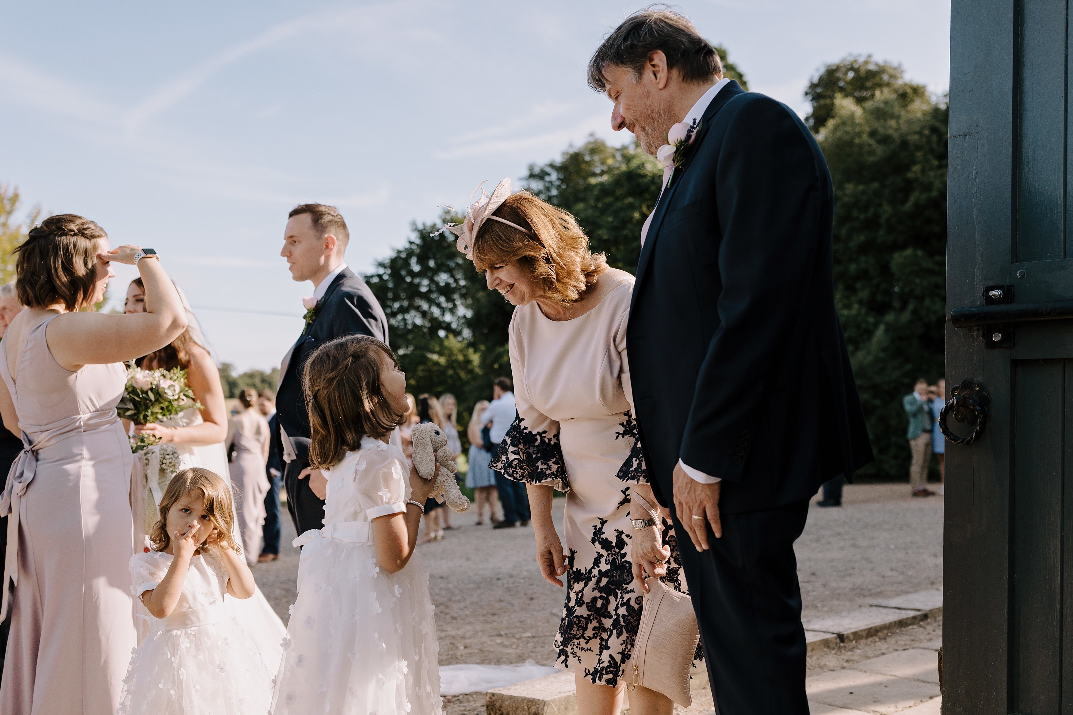 Two flower girls talking to wedding guests