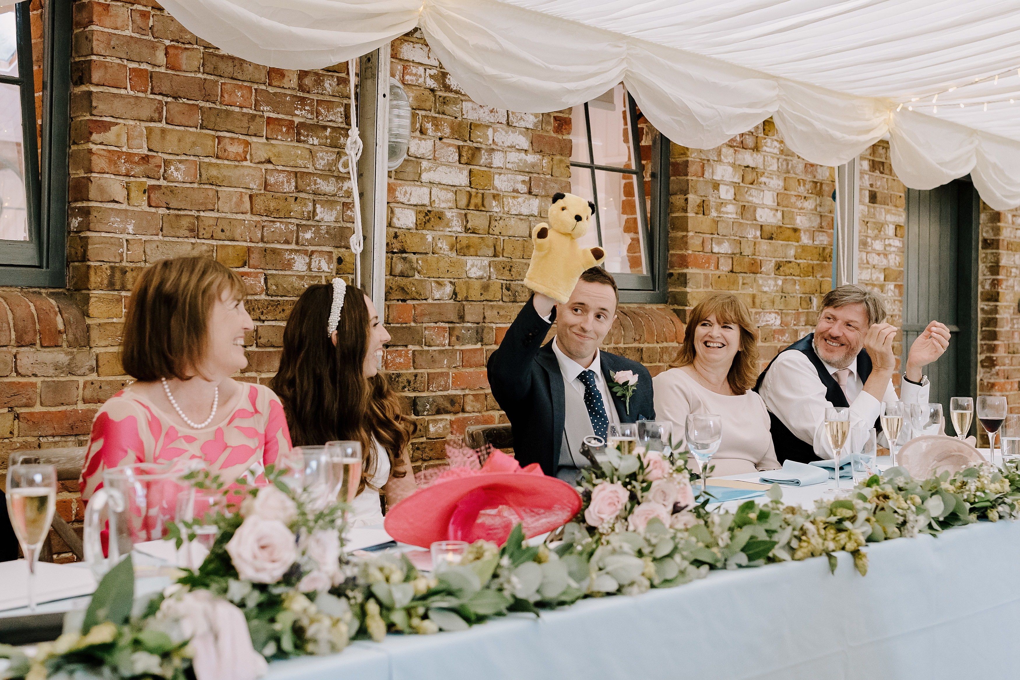 The groom with a puppet on his hand during wedding speeches