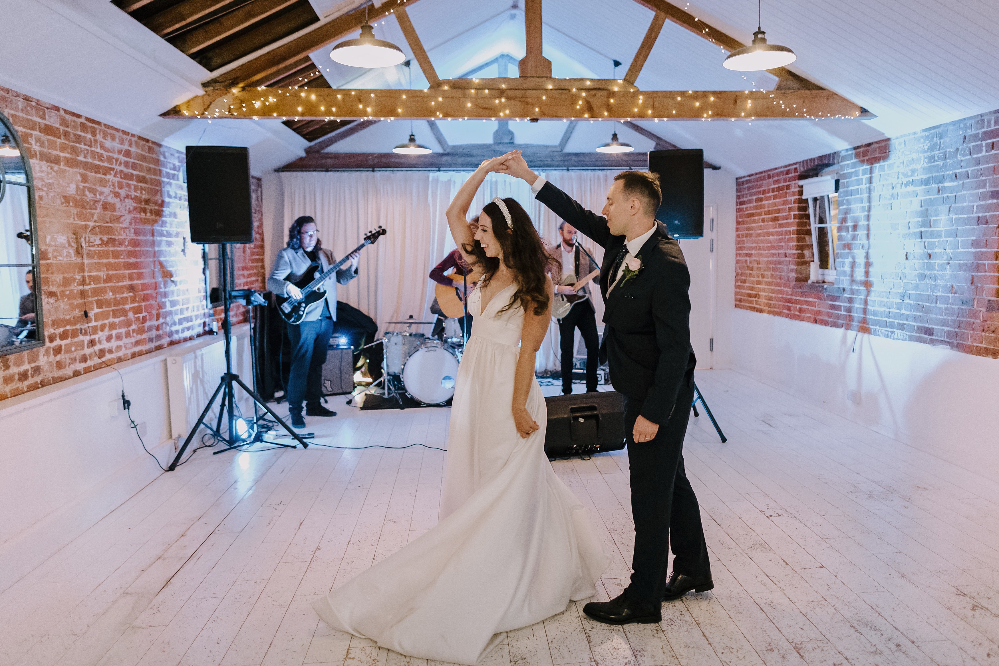 The groom spinning his bride during the first dance with wedding band in the background