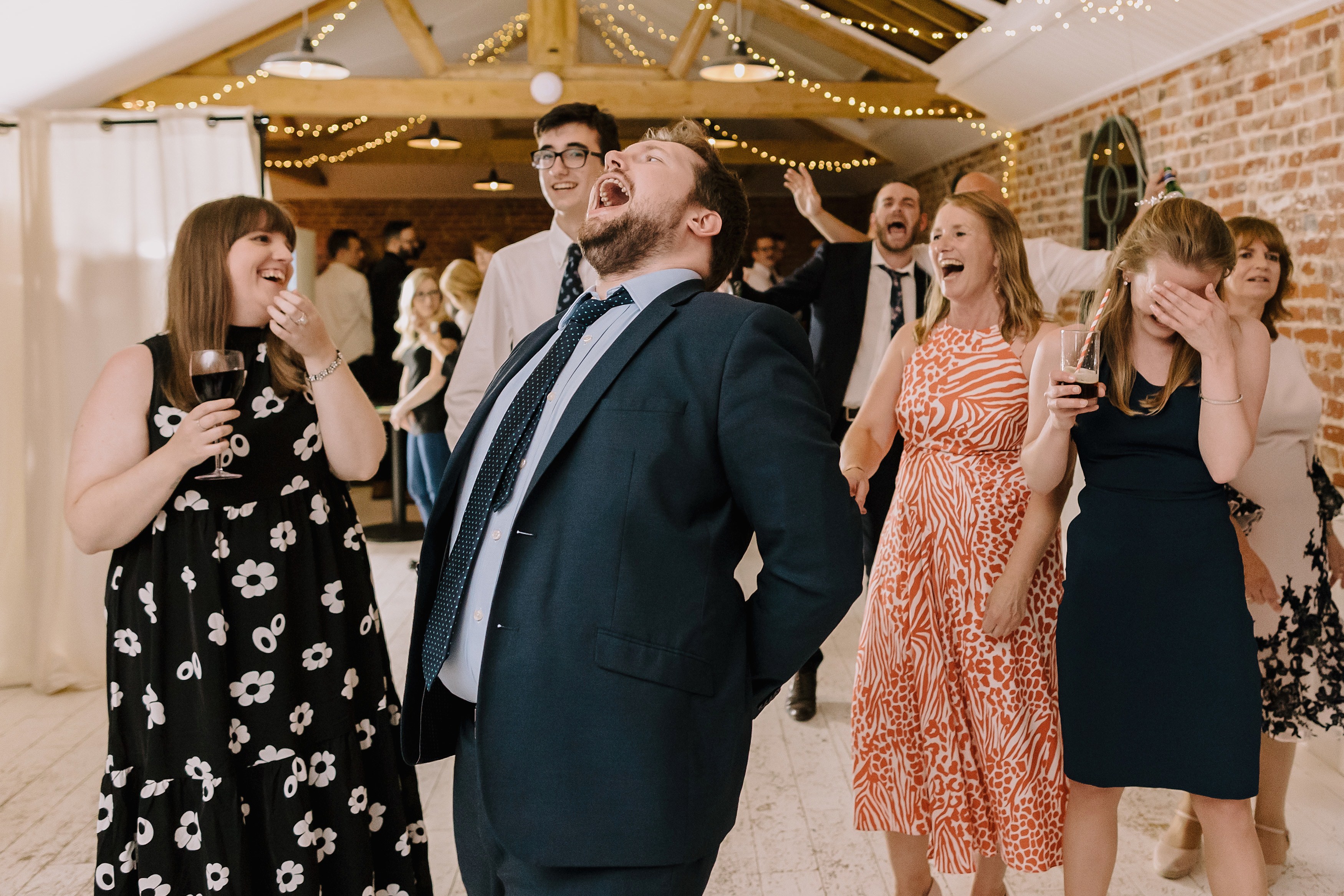 A group of wedding guests laughing during the wedding reception