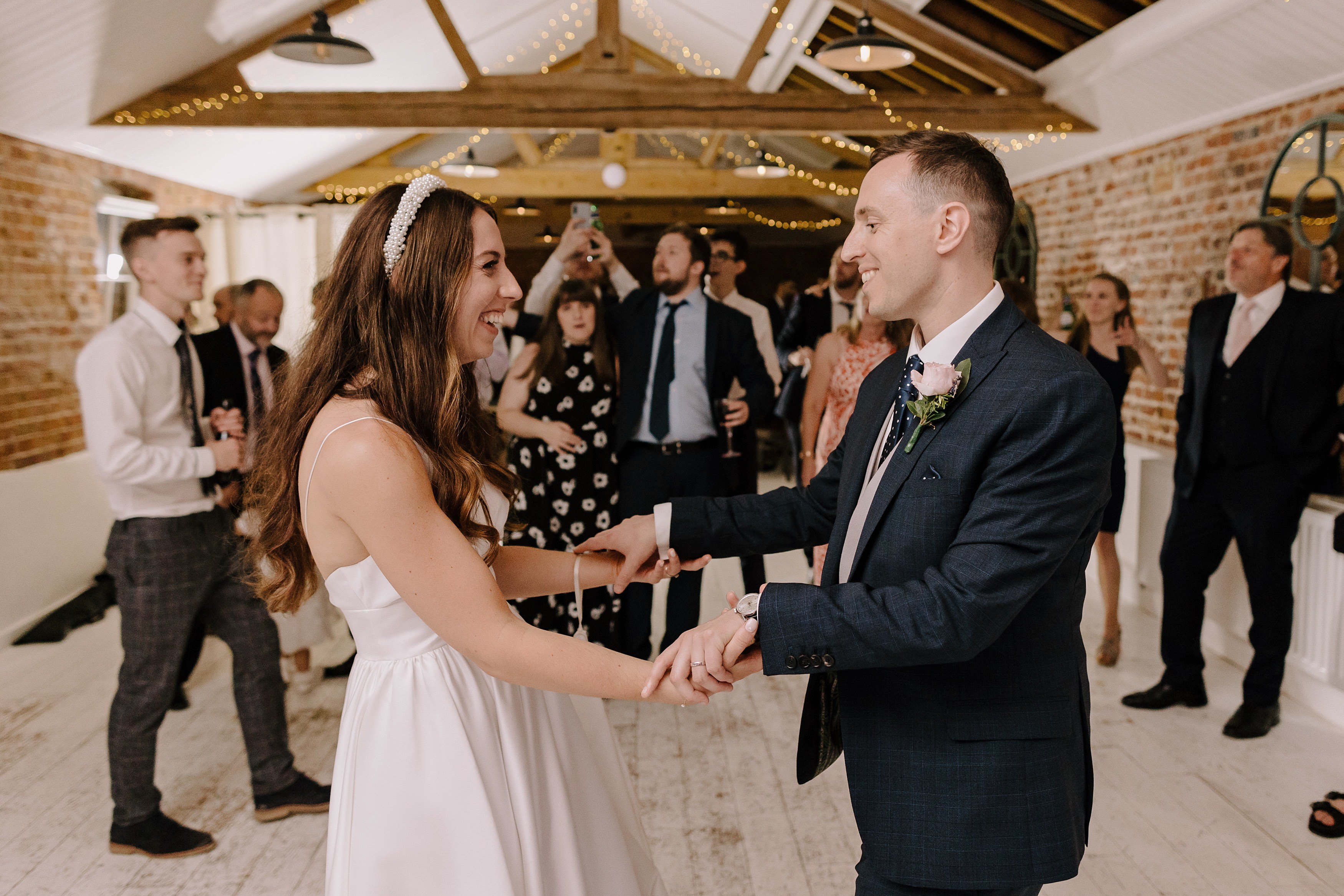 The bride and groom dancing together among their wedding guests