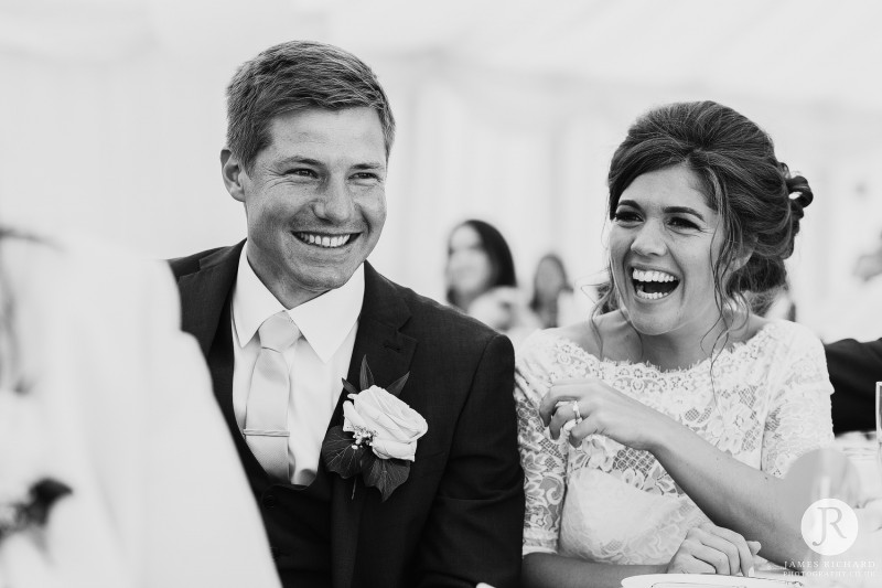 bride and groom laughing at speeches