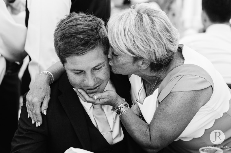 Mother of the bride kisses groom
