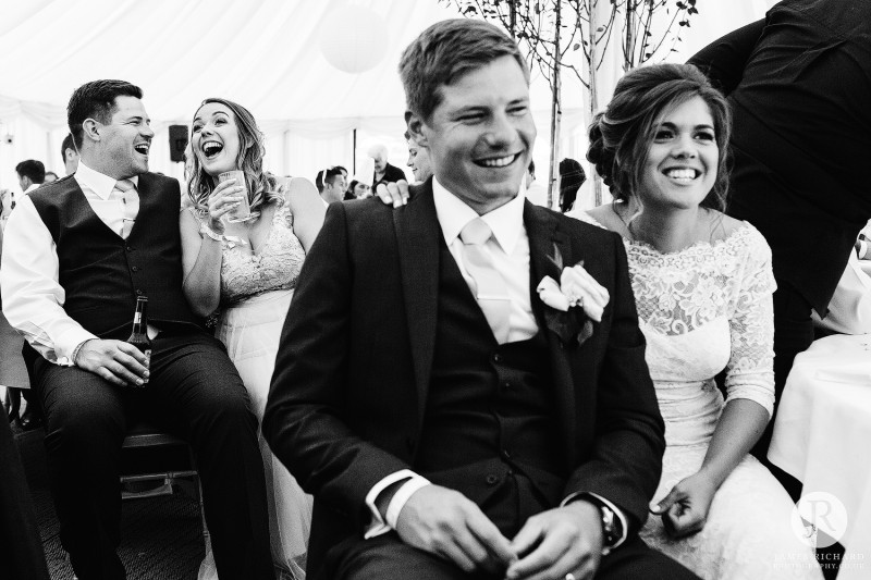 Bride and groom and brother and sister laughing together 