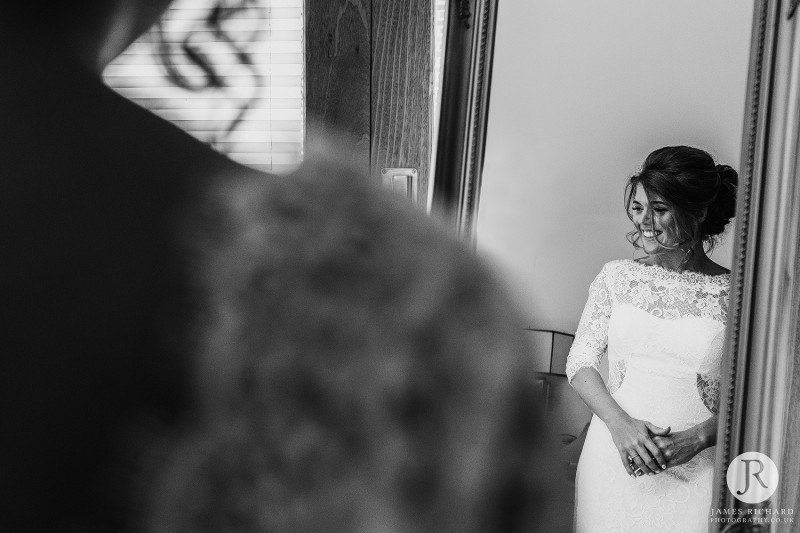 bride smiling as she sees her reflection in the mirror