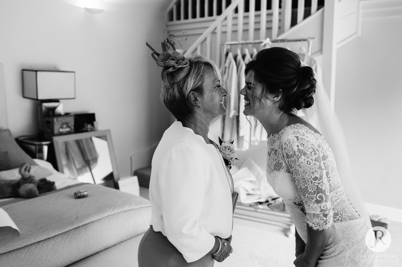 Mother of the bride and bride looking at each other as they smile