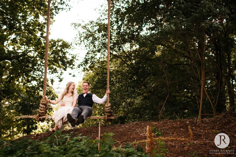 Couple having fun on swing at Wilderness Weddings Kent
