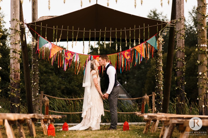 Couple kissing in front of the lake at Wilderness Weddings 