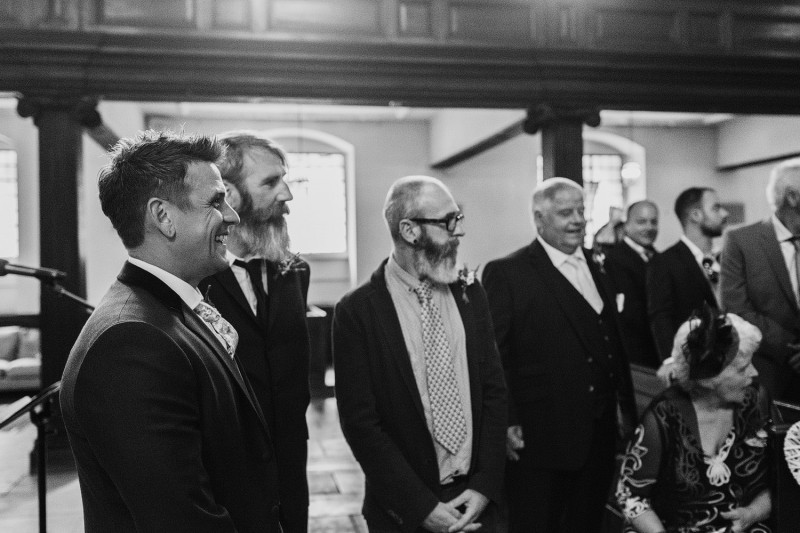 Groom watches his beautiful bride walking down the aisle 