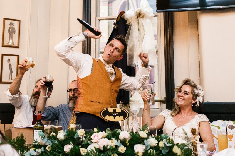 Super happy groom throws his hands up in the air
