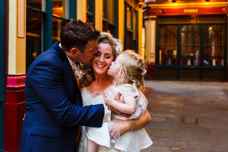 cute photo of bride, groom and daughter kissing