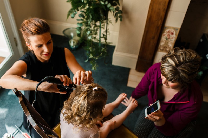 Hairdresser doing little girl's hair